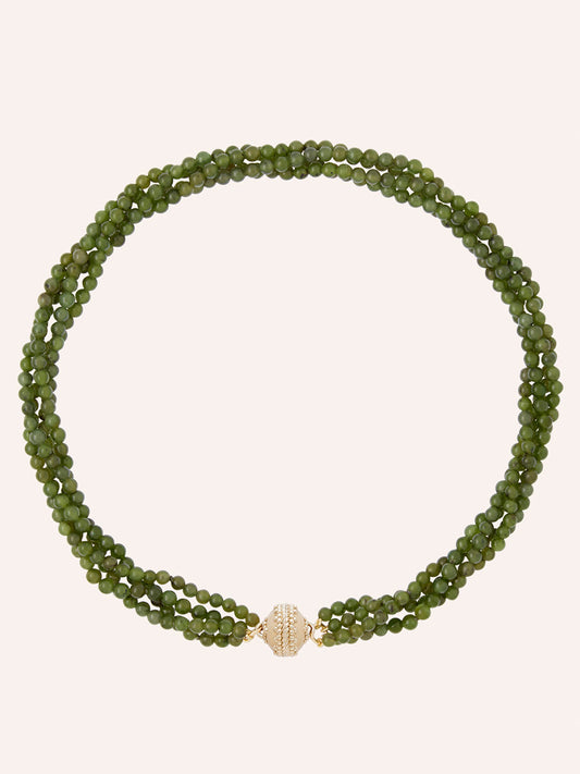 The Clara Williams Victoire 4mm Green Jade Multi-Strand Necklace, featuring three strands of green jade beads and a round 14K gold clasp adorned with small clear stones, is displayed on a plain background.