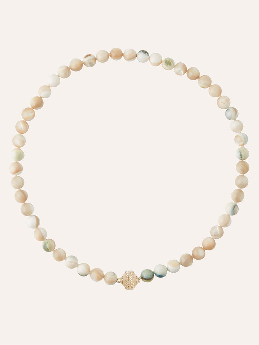 The Clara Williams Victoire 8mm Green Shell Turban Mini Necklace showcases round, green shell beads accented with a single textured gold centerpiece, echoing the refined Clara Williams style. A touch of 14K yellow gold brings added sophistication to this elegant design, beautifully presented against a plain light background.