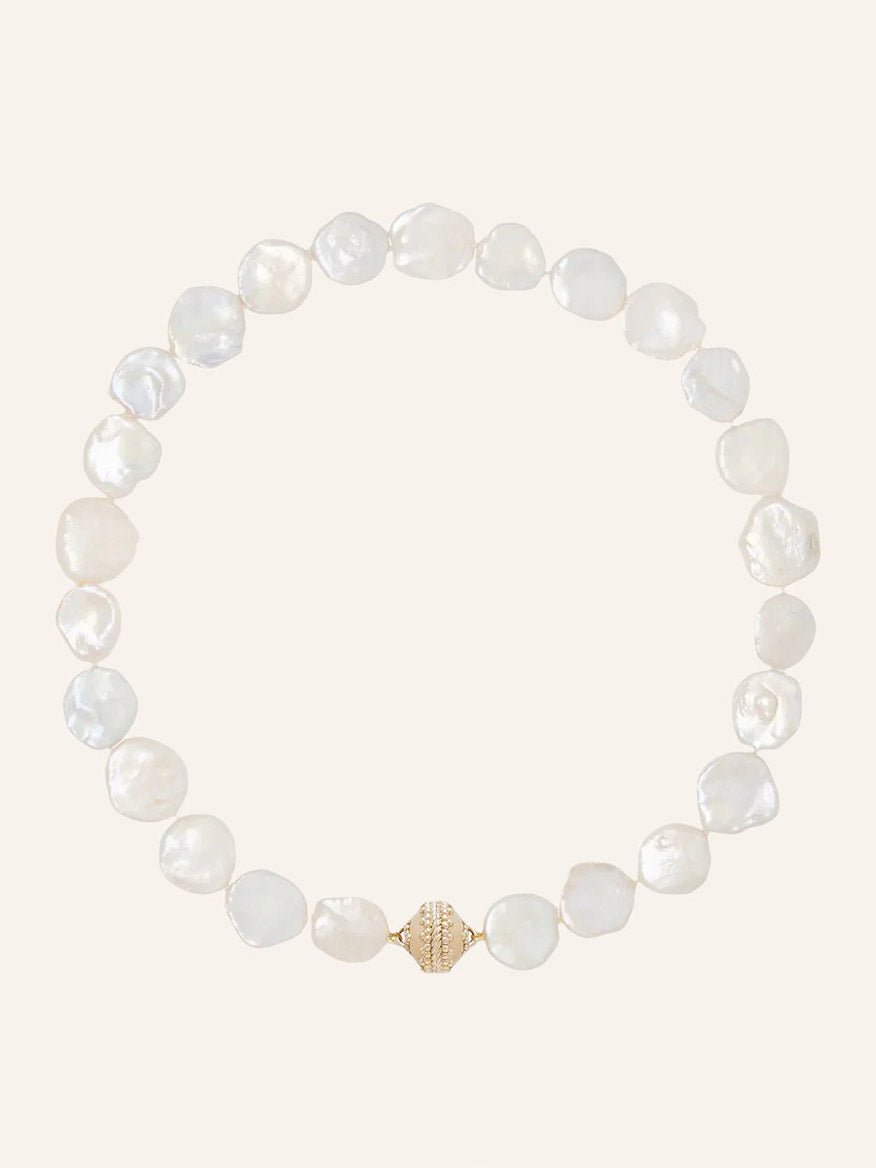 Clara Williams White Keshi Pearl Necklace featuring irregularly shaped white pearls and a textured 14K gold clasp, displayed in a circular arrangement on a plain light background.