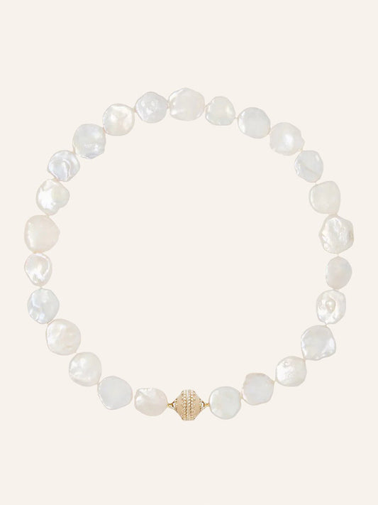 Clara Williams White Keshi Pearl Necklace featuring irregularly shaped white pearls and a textured 14K gold clasp, displayed in a circular arrangement on a plain light background.