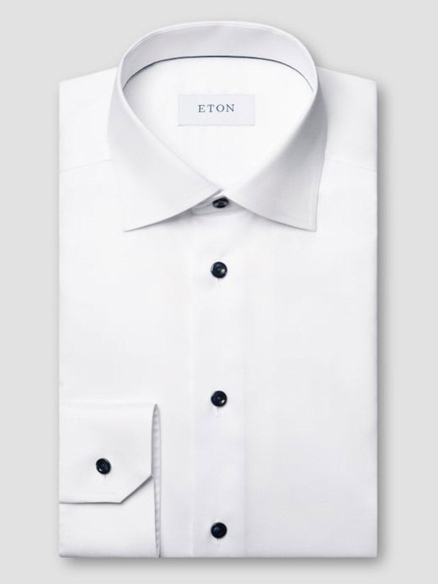 A neatly folded Eton Classic Fit Solid Signature Twill Dress Shirt in white, featuring a classic collar, navy details, and an inside collar label reading "ETON.