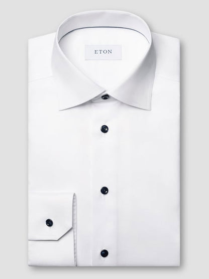 A neatly folded Eton Classic Fit Solid Signature Twill Dress Shirt in white, featuring a classic collar, navy details, and an inside collar label reading "ETON.