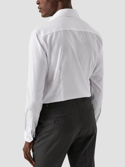 A man wearing the Eton Classic Fit Twill Dress Shirt in White, wrinkle-free and shown from the back with dark gray trousers against a plain light background—a versatile shirt for any occasion.