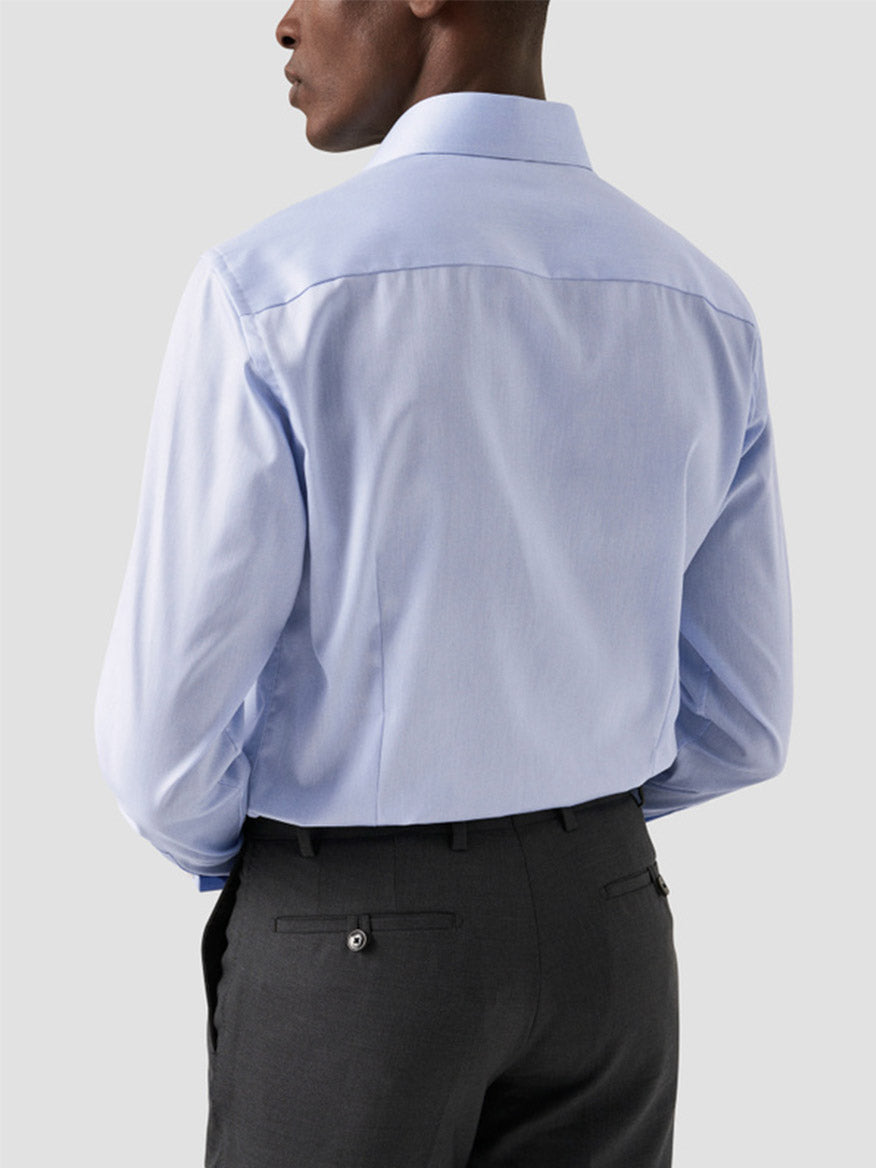 A person wearing an Eton Slim Fit Extreme Cut Away Dress Shirt in Sky Blue and dark gray dress pants, shown from the back against a plain light background.