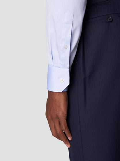 A person wearing the Eton Slim Fit Extreme Cut Away Dress Shirt in Sky Blue and dark trousers; the focus is on the crisp organic cotton cuff and part of the hand and arm.