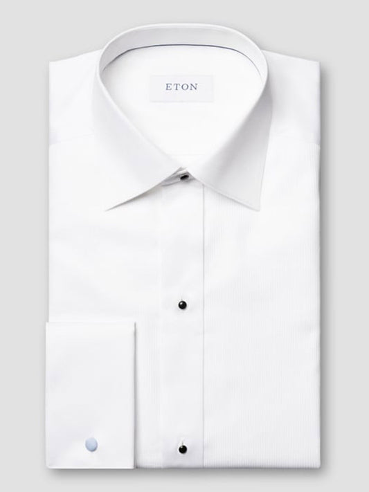 A neatly folded Eton Contemporary Fit Fine Striped Bib Evening Shirt in White with French cuffs, pointed collar, and black buttons, featuring the ETON brand label inside the collar.