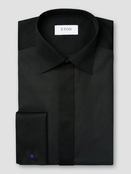 A neatly folded Eton Contemporary Fit Fine Striped Bib Evening Shirt in black with French cuffs, featuring a visible Eton brand label inside the collar.