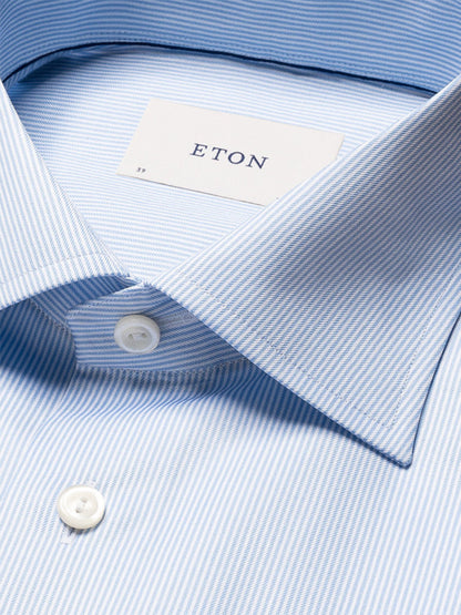 Close-up of the Eton Contemporary Fit Fine Striped Signature Twill Dress Shirt in light blue, featuring white buttons and the "ETON" label inside the collar—a true business classic.