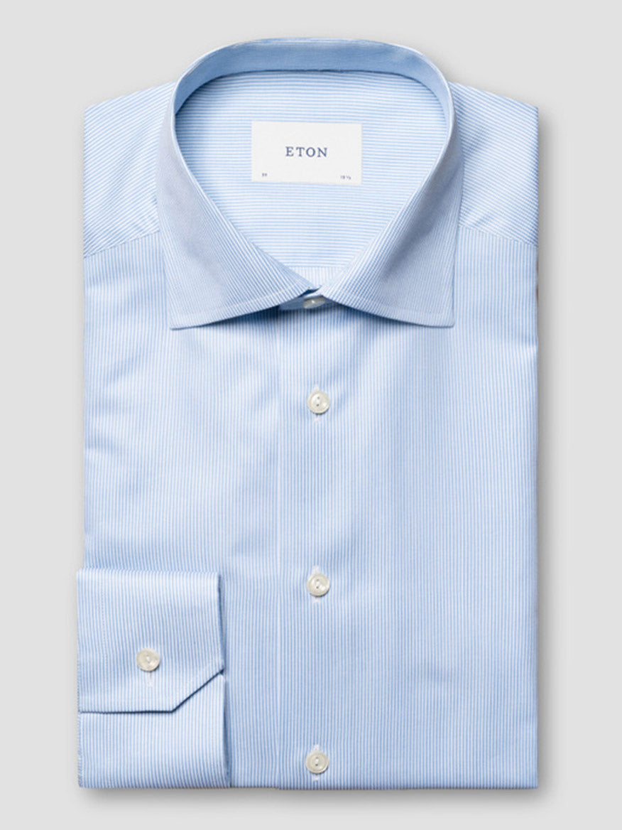 The Eton Contemporary Fit Fine Striped Signature Twill Dress Shirt in Light Blue features a subtle stripe, white buttons, and a spread collar—a business classic presented against a plain backdrop.