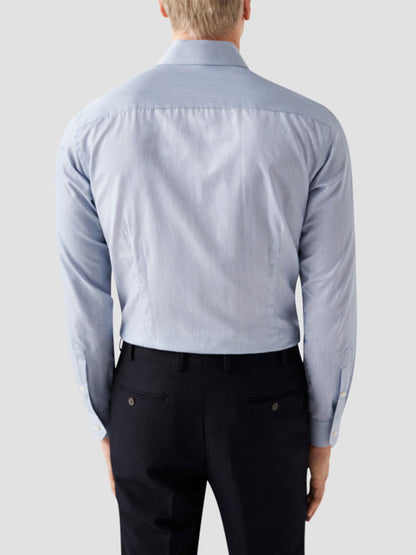 A man is shown from the back wearing an Eton Slim Fit Fine Striped Signature Twill Dress Shirt in Mid Blue and black dress pants against a plain light gray background, highlighting a timeless business classic style.