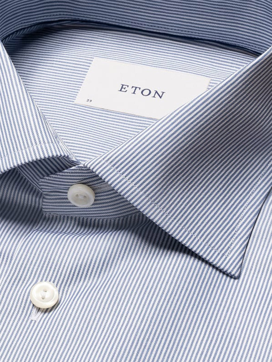 Close-up of the Eton Slim Fit Fine Striped Signature Twill Dress Shirt in Mid Blue, featuring classic blue and white stripes, white buttons, and the Eton label.
