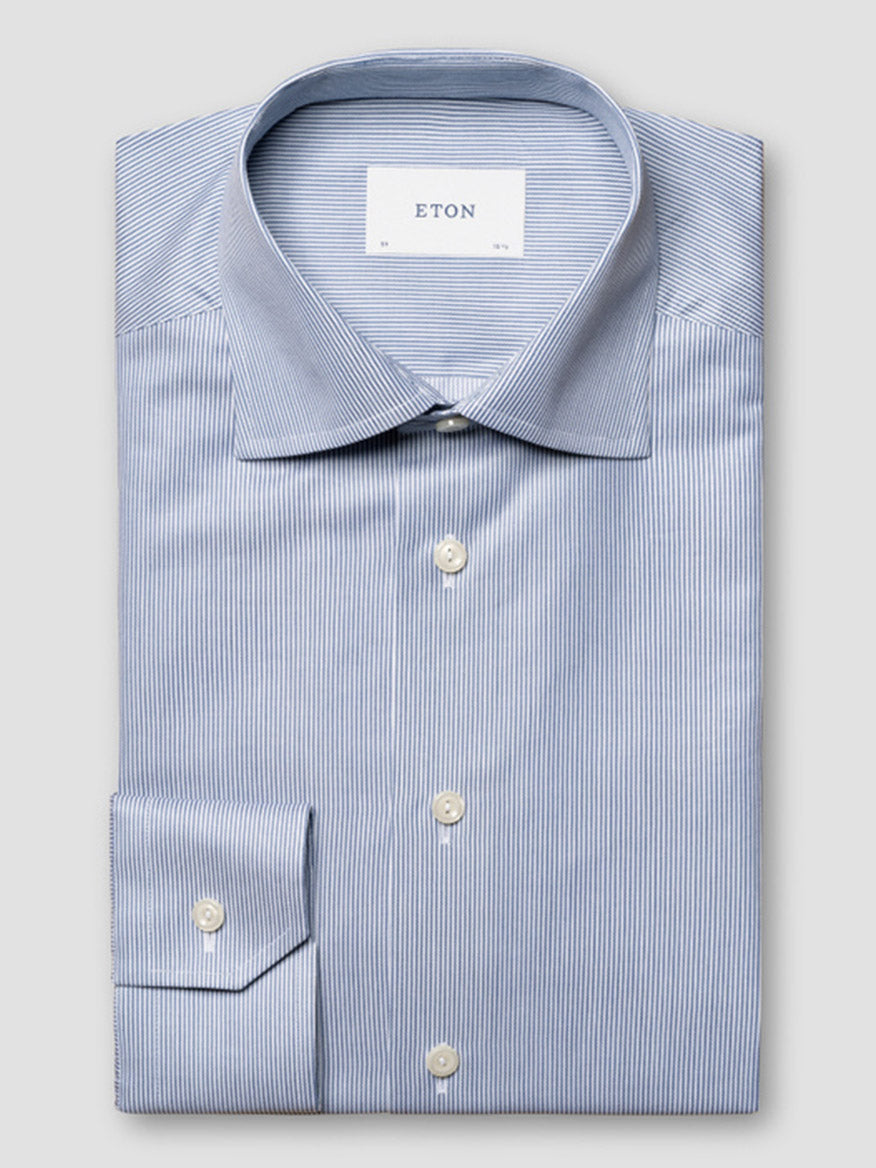 The Eton Slim Fit Fine Striped Signature Twill Dress Shirt in Mid Blue features a spread collar, white buttons, and thin white stripes—an ideal choice for a classic business look.
