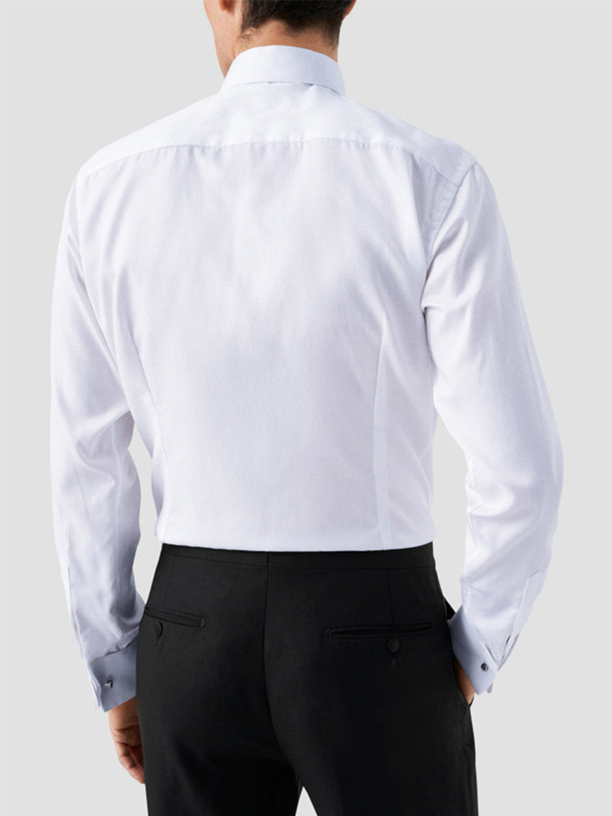 A man is shown from the back wearing an Eton Slim Fit Fly Front Evening Dobby Shirt in white and black dress pants against a plain light background.