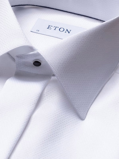 Close-up of the Eton Slim Fit Fly Front Evening Dobby Shirt in White, featuring a textured finish, pointed collar, black button, and “ETON” label with size 39. Crafted from premium organic cotton for an elegant look.