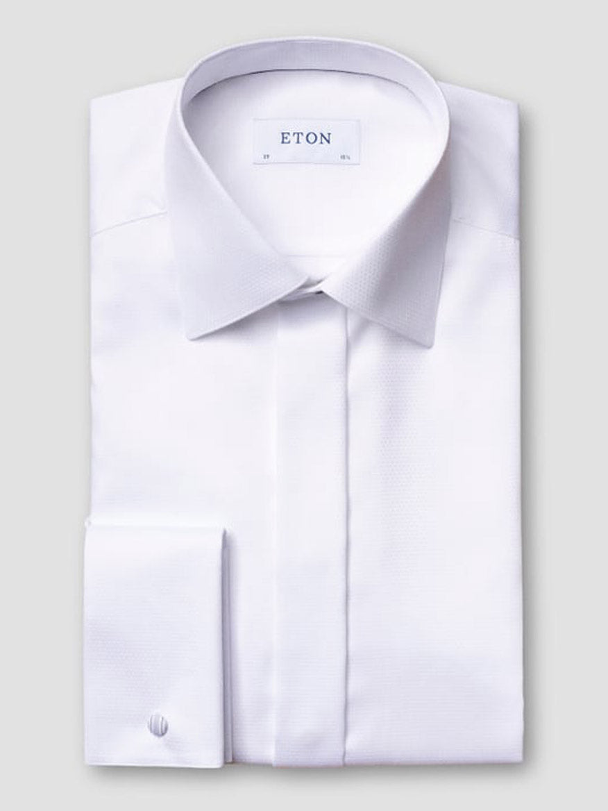 The Eton Slim Fit Fly Front Evening Dobby Shirt in White, featuring a pointed collar and French cuffs, is neatly folded with the “Eton” label visible inside the collar against a plain light gray background.