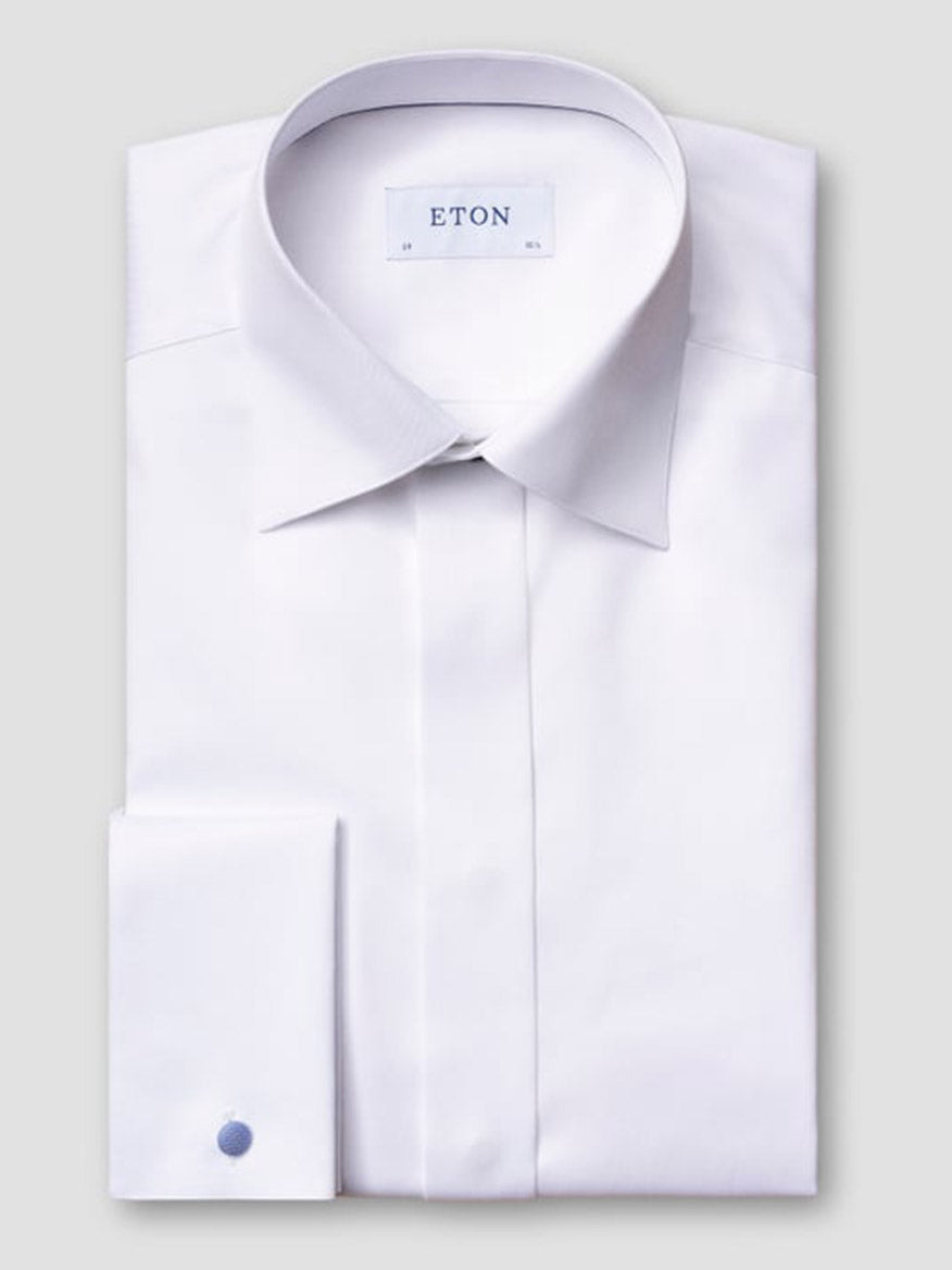 The Eton Contemporary Fit Fly Front Signature Twill Evening Shirt in White, made from organic cotton with a spread collar and French cuffs, is neatly folded and displayed against a plain gray background.