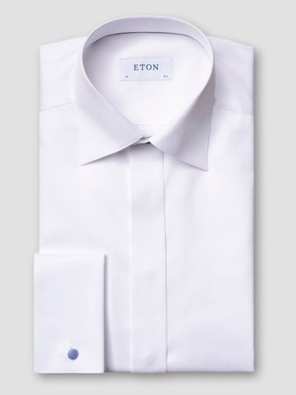 The Eton Contemporary Fit Fly Front Signature Twill Evening Shirt in White, made from organic cotton with a spread collar and French cuffs, is neatly folded and displayed against a plain gray background.