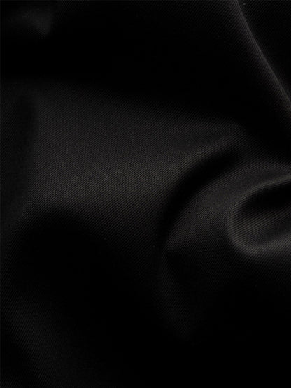 Close-up of the Eton Contemporary Fit Solid Signature Twill Dress Shirt in Black with French cuffs, highlighting its textured organic cotton fabric and subtle folds that create elegant shadow and light play.