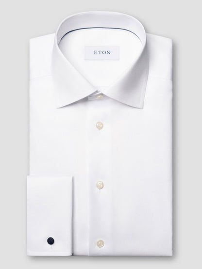 A neatly folded Eton Contemporary Fit Solid Signature Twill Dress Shirt in White with French cuffs is displayed against a light gray background.