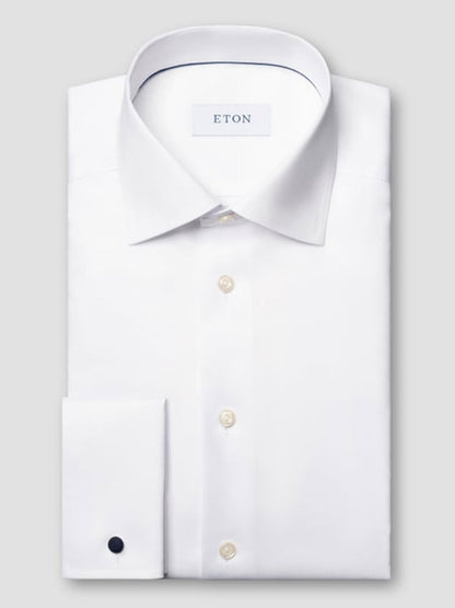 A folded white Eton Slim Fit Solid Signature Twill Dress Shirt with French cuffs, classic collar, buttoned front, and a visible Eton label inside the collar.