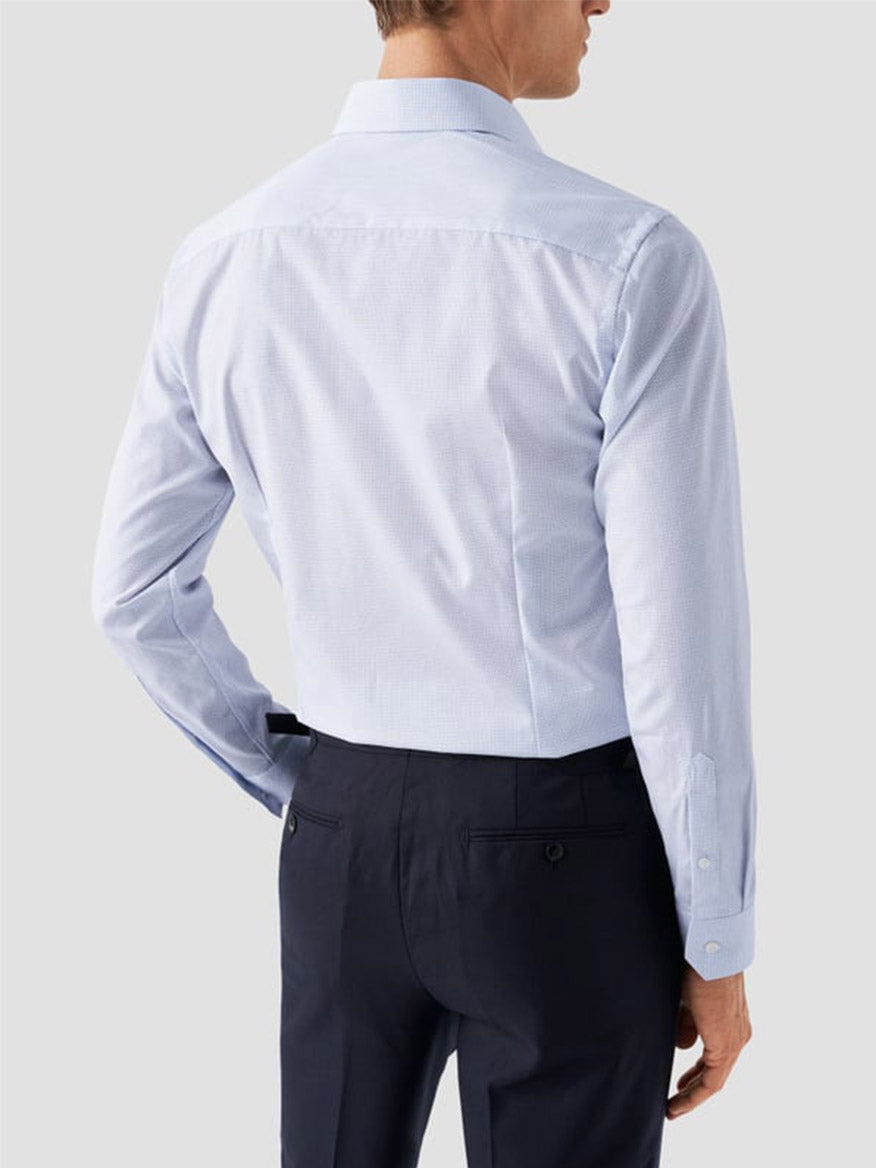A man is shown from the back wearing the Eton Slim Fit Geometric Print Poplin Dress Shirt in Sky Blue and dark trousers against a plain light gray background.