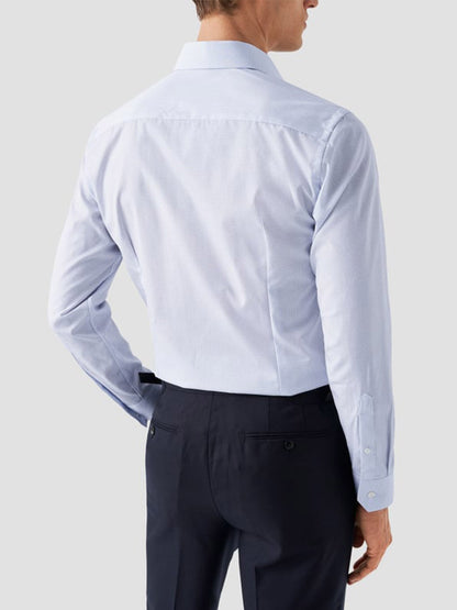 A man is shown from the back wearing the Eton Slim Fit Geometric Print Poplin Dress Shirt in Sky Blue and dark trousers against a plain light gray background.