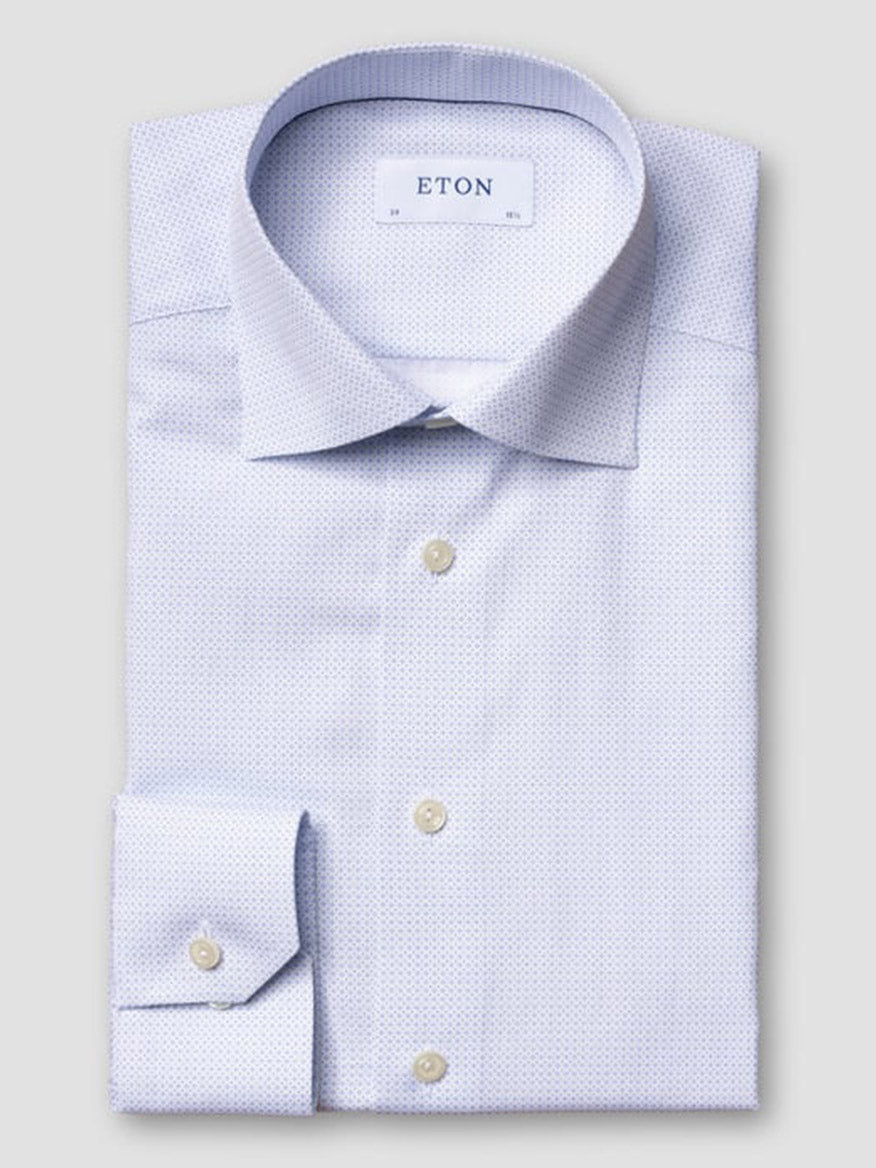 The Eton Slim Fit Geometric Print Poplin Dress Shirt in Sky Blue features a cutaway collar, white buttons, and a subtle geometric pattern, displayed neatly folded with the "ETON" label visible on the collar against a plain background.