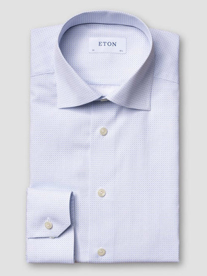 The Eton Slim Fit Geometric Print Poplin Dress Shirt in Sky Blue features a cutaway collar, white buttons, and a subtle geometric pattern, displayed neatly folded with the "ETON" label visible on the collar against a plain background.