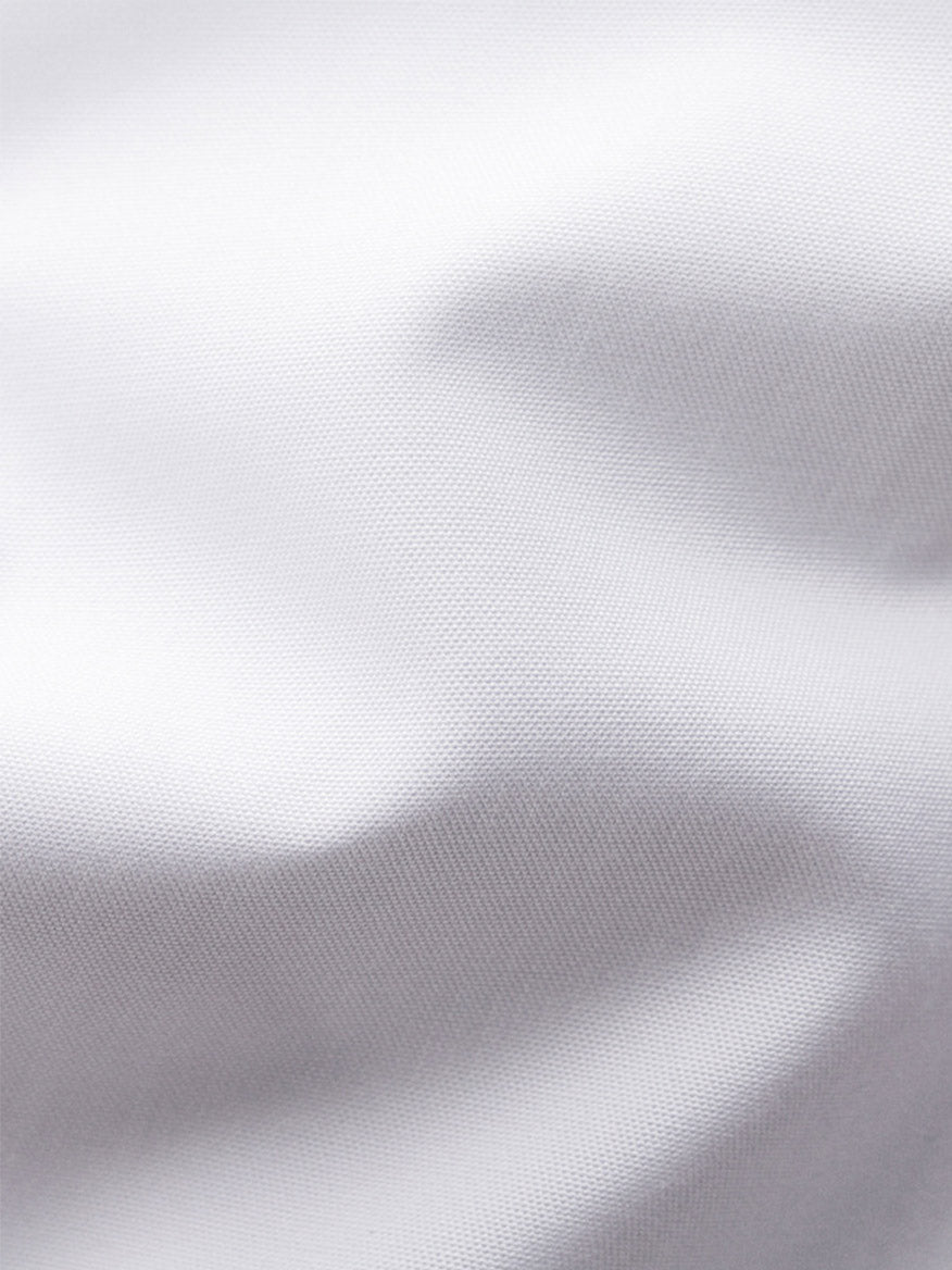 Close-up of white fabric with visible texture and soft folds, showing subtle shadows—perfect details found in the Eton Contemporary Fit Plissé Black Tie Dress Shirt, ideal for a formal shirt or classic tuxedo shirt with a pleated front.