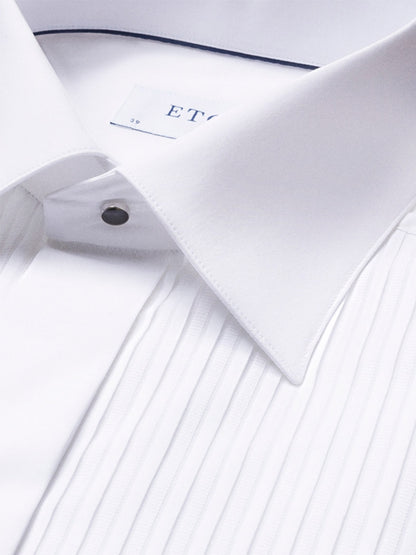 Close-up of the Eton Slim Fit Plissé Bib-Front Tuxedo Shirt in White, showcasing its pleated front, spread collar, and metallic stud buttons—ideal for black-tie events.