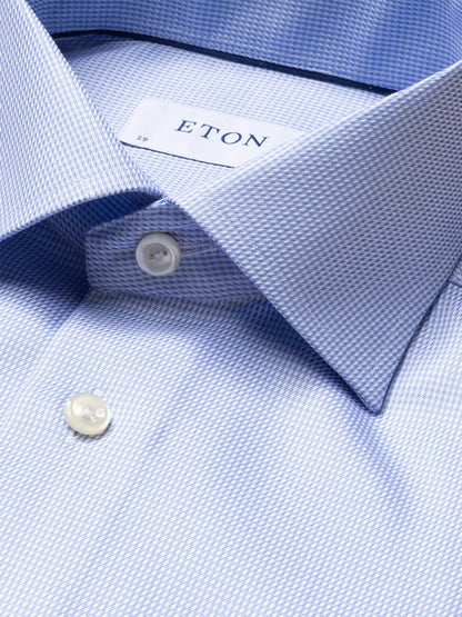 Close-up of the Eton Contemporary Fit Semi Solid Dobby Dress Shirt in light blue, featuring a textured pattern, white buttons, and a visible Eton label inside the collar.