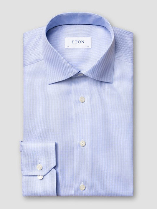The Eton Contemporary Fit Semi Solid Dobby Dress Shirt in Light Blue features a textured fabric, spread collar, white buttons, and the "ETON" brand label inside the collar.