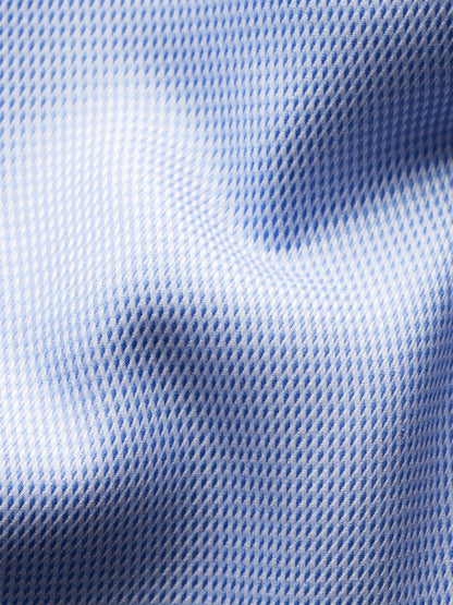Close-up of the Eton Slim Fit Semi Solid Dobby Dress Shirt in Light Blue, featuring textured fabric with a subtle repeating pattern and gentle folds.