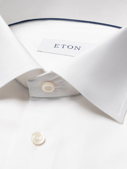 Close-up of the Eton Contemporary Fit Semi Solid Dress Shirt in White, showing its pointed collar, white buttons, and the Eton brand label inside.
