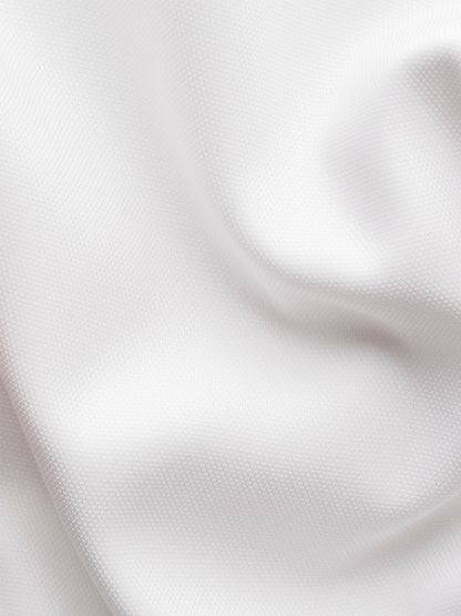 Close-up of white textured, wrinkle-free fabric with soft folds and gentle shadows, ideal for the Eton Contemporary Fit Semi Solid Dress Shirt in White.