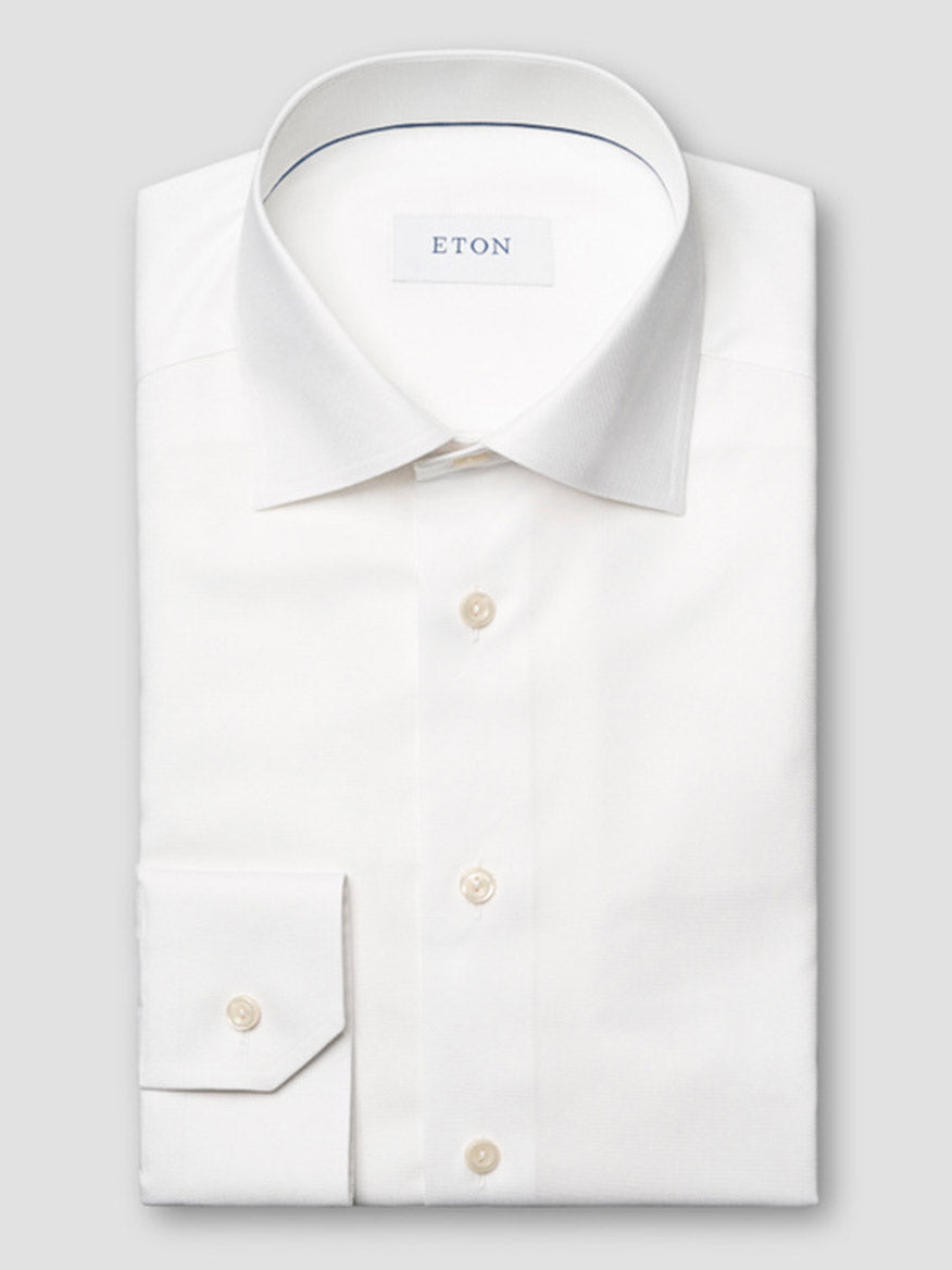 The Eton Contemporary Fit Semi Solid Dress Shirt in White features a neatly folded design with a pointed collar, buttoned cuffs, and the "ETON" label visible inside the collar.