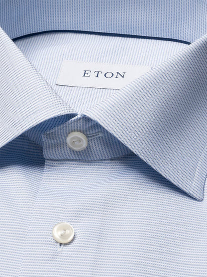 Close-up of the Eton Contemporary Fit Semi Solid Dress Shirt in Light Blue, showcasing its spread collar, white buttons, and a subtle textured pattern.