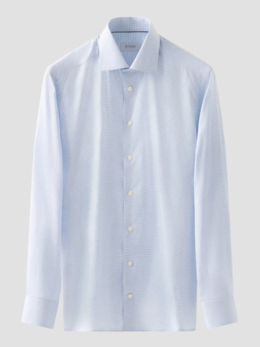 The Eton Contemporary Fit Semi Solid Dress Shirt in Light Blue features long sleeves, a button-up front with white buttons, a classic collar, subtle texture, and wrinkle-free organic cotton—shown against a plain background.