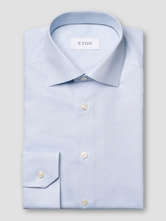 A neatly folded Eton Slim Fit Semi Solid Dress Shirt in light blue with a cut away collar, classic buttoned cuffs, and the Eton brand label inside.