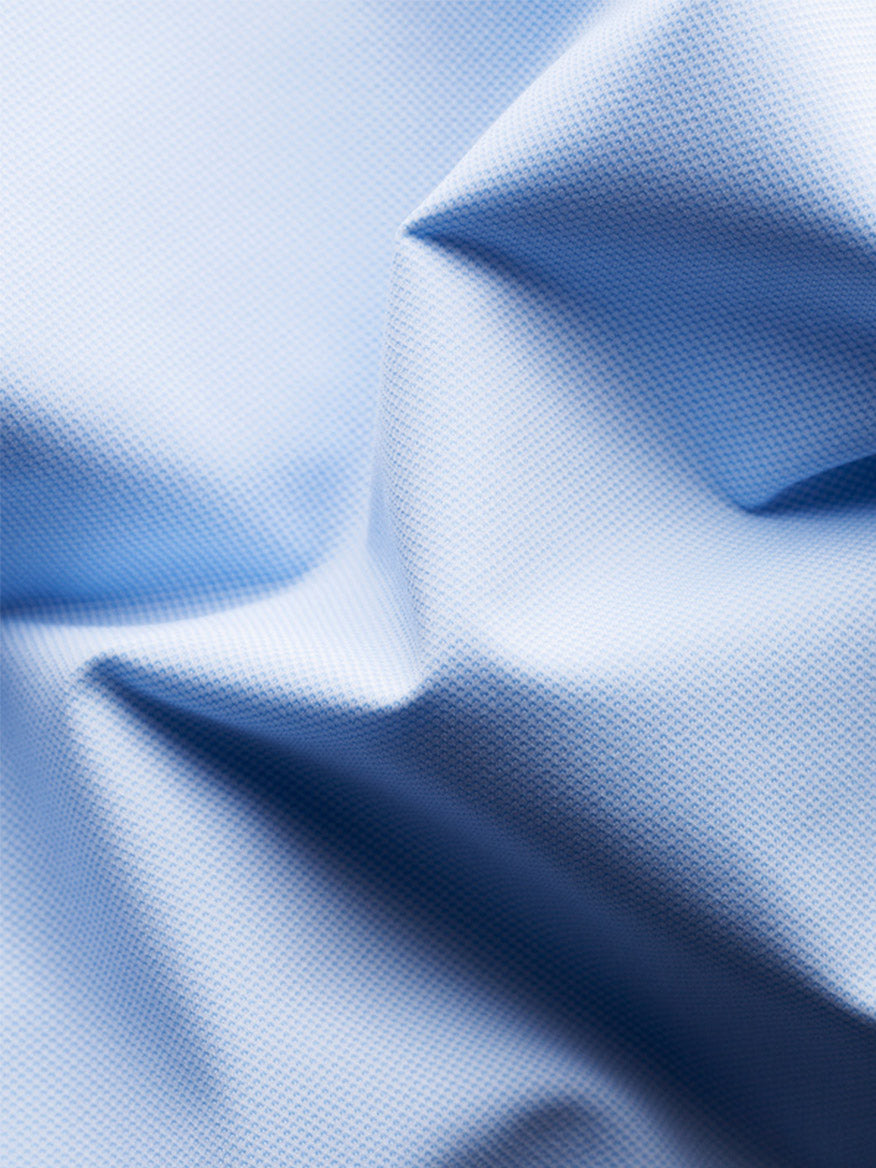 Close-up of the Eton Slim Fit Semi Solid Four-Way Stretch Shirt in Light Blue, showing textured fabric with visible folds and creases.