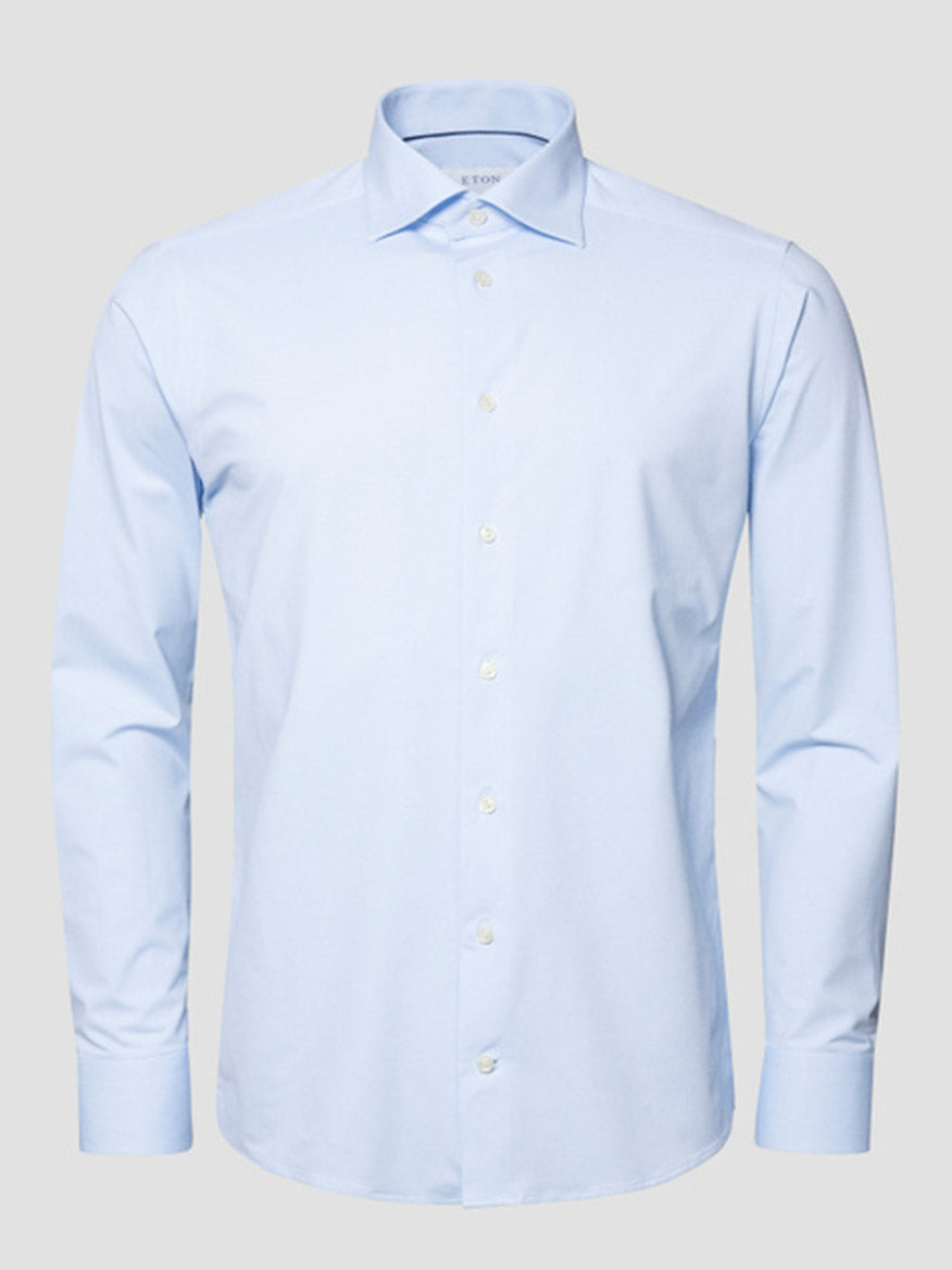 The Eton Slim Fit Semi Solid Four-Way Stretch Shirt in Light Blue, featuring long sleeves and a button-up design, is shown against a plain gray background.