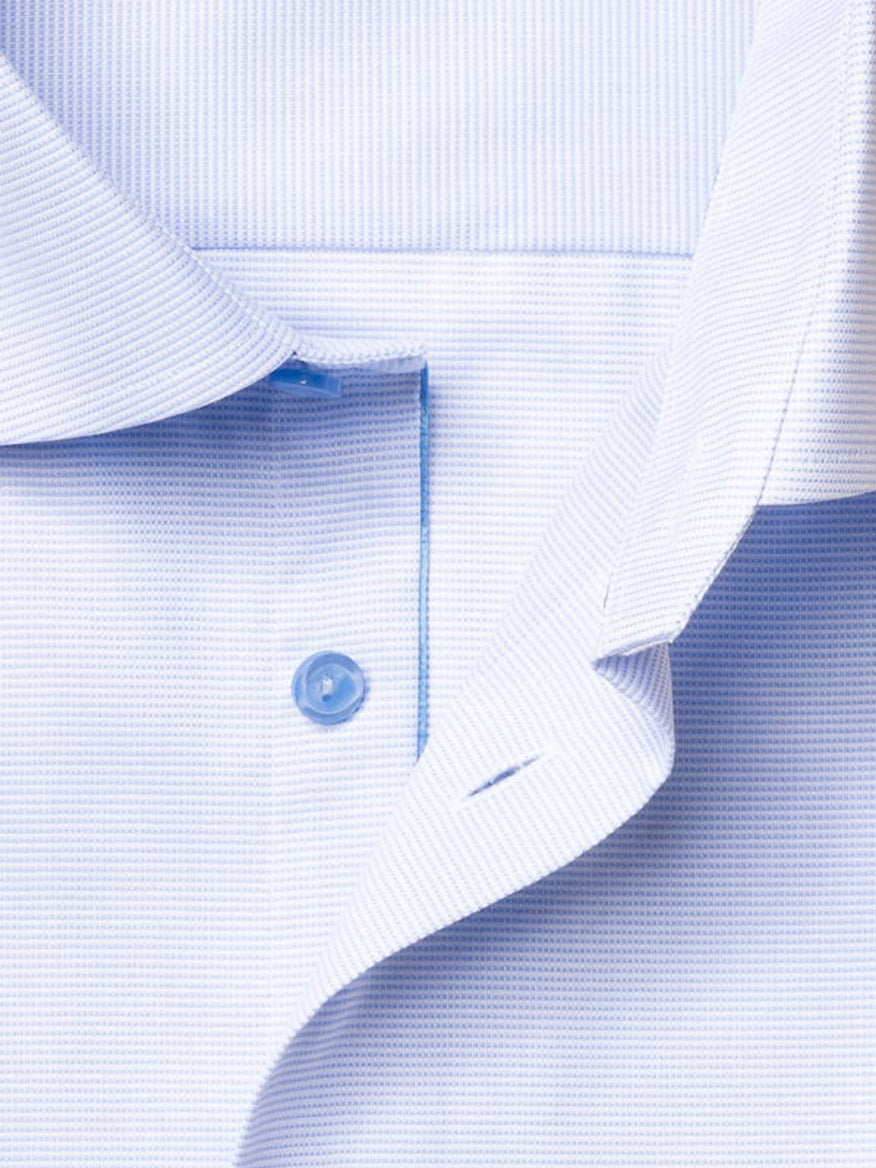 Close-up of the Eton Contemporary Fit Semi Solid Piping Details Shirt in Light Blue, featuring the button placket, a single blue button, and part of the collar in an Oxford style.