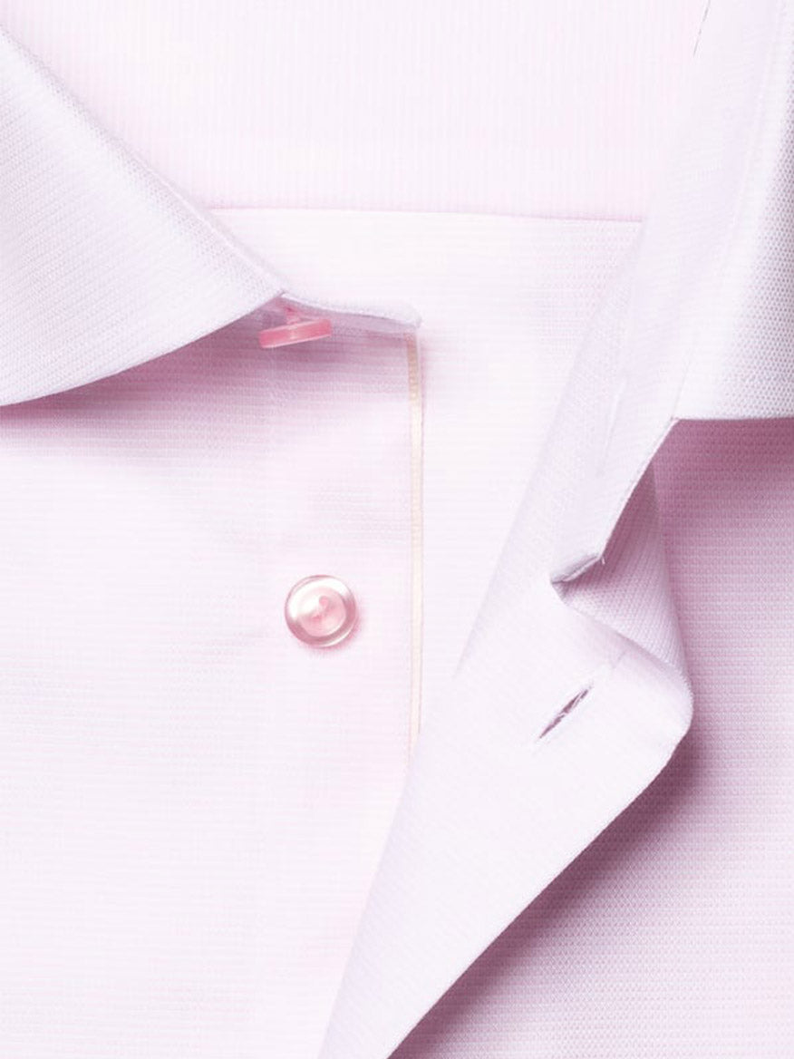 Close-up of the Eton Slim Fit Semi Solid Piping Details Shirt in Pink, showcasing its light pink Oxford cotton, Cut Away collar, button, and part of the buttonhole placket.