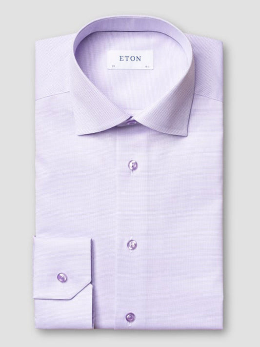 A neatly folded Eton Slim Fit Semi Solid Piping Details Shirt in light purple, featuring a cut away collar, buttoned cuffs, and the “ETON” brand label inside the collar.