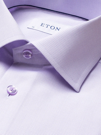 Close-up of the Eton Contemporary Fit Semi Solid Piping Details Dress Shirt in light purple, highlighting its cut away collar, buttons, and branded label for a refined, modern look.
