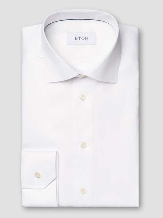 The Eton Contemporary Fit White Signature Twill Dress Shirt, featuring a pointed collar and buttoned cuffs, is neatly folded and displayed on a light gray background.