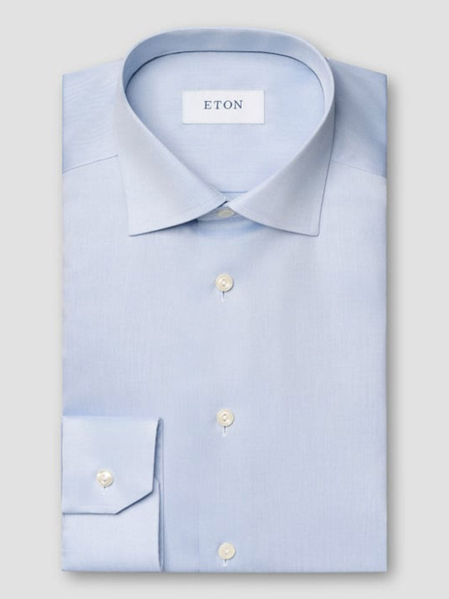 The Eton Contemporary Fit Light Blue Signature Twill Dress Shirt features a pointed collar, white buttons, and an Eton brand label inside the collar. Its wrinkle-free design ensures effortless style throughout the day.