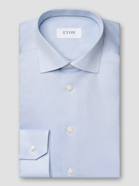 The Eton Contemporary Fit Light Blue Signature Twill Dress Shirt features a pointed collar, white buttons, and an Eton brand label inside the collar. Its wrinkle-free design ensures effortless style throughout the day.