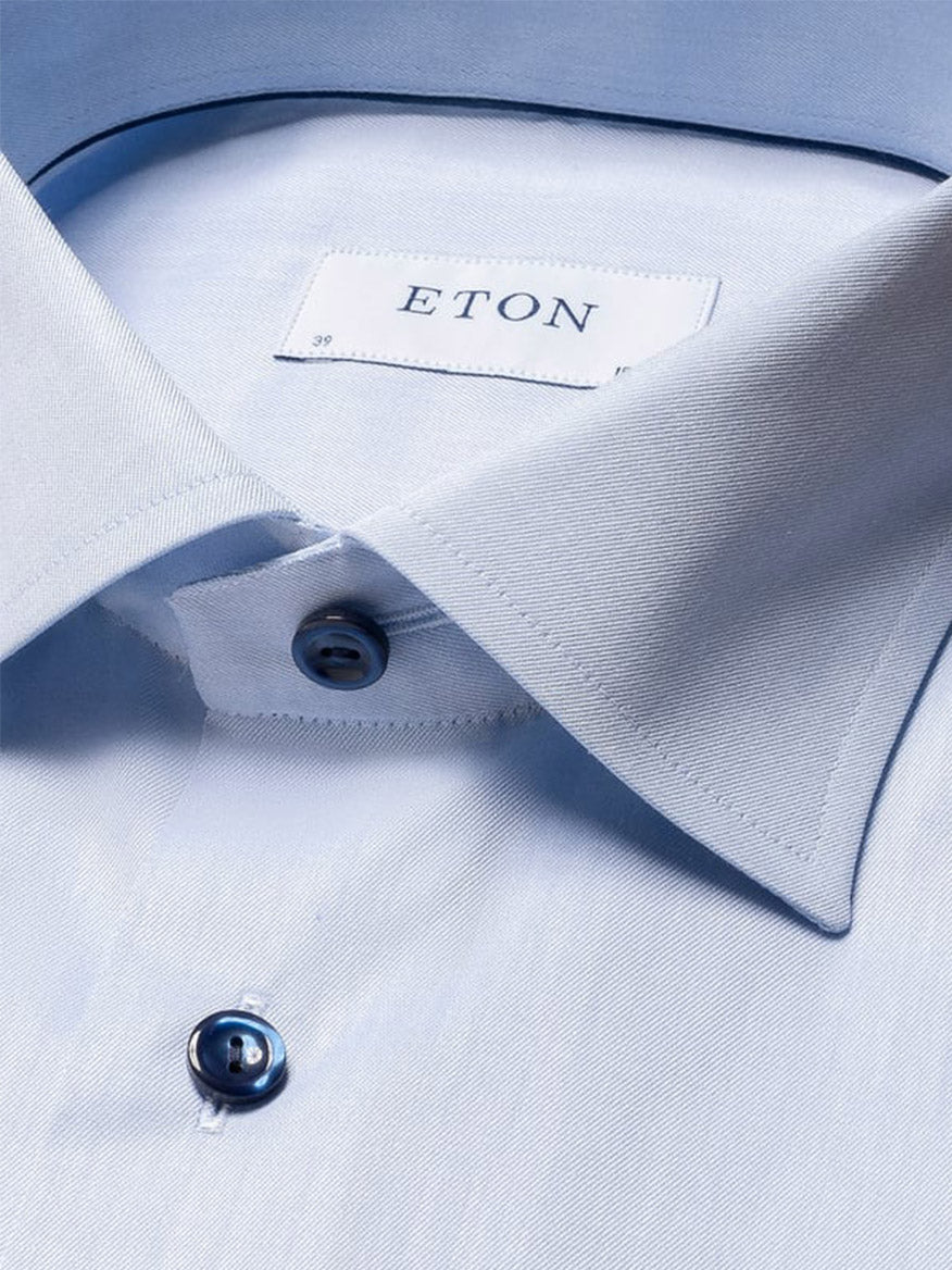 Close-up of the Eton Contemporary Fit Signature Twill Dress Shirt in light blue with navy details, featuring a pointed collar, fastened top button, and a visible Eton label inside the collar.
