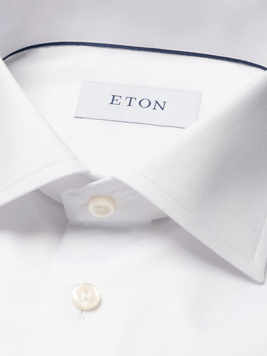 Close-up of the Eton Slim Fit Solid Signature Twill Dress Shirt in White, featuring a pointed collar, single cuff, white buttons, and an Eton brand label inside the neck.